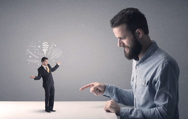 Young professional businessman being angry with an other miniature businessman who has scribbles above his head