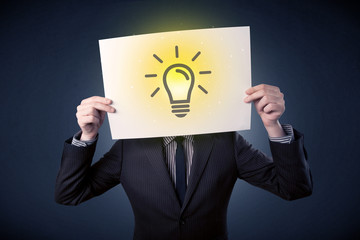 Young businessman hiding behind a lightbulb drawn on paper