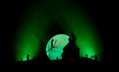 Scary view of zombies at cemetery dead tree, moon, church and spooky cloudy sky with fog, Horror...