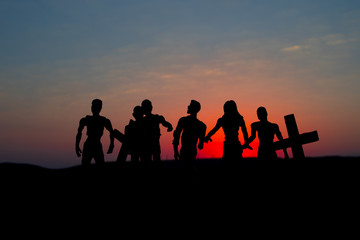Fototapeta na wymiar Silhouette some zombies on the cemetery walking around at sunset