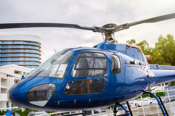 Helicopter parked at the helipad after a rain. Blue helicopter by close-up.