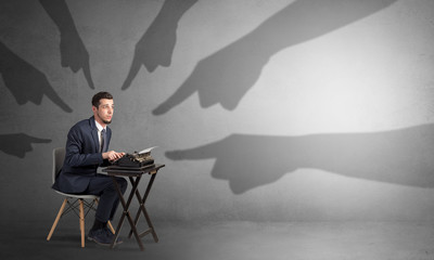Shadow hand pointing at a small afraid worker
