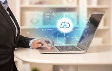 Business woman in homey environment using laptop with  online storage and cloud technology concept

