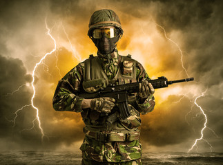 Armed soldier standing in rainy obscure weather

