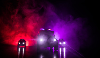 Police car chasing a car at night with fog background. 911 Emergency response police car speeding...