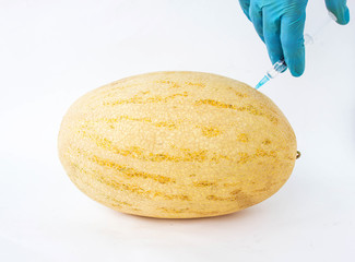 Melon on a white background in which enter gmo and nitrates, close-up, genetically modified...