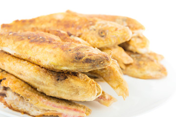 Dish of fried fishes red mullets isolated on white background