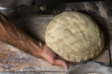 Male hands kneading dough on sprinkled