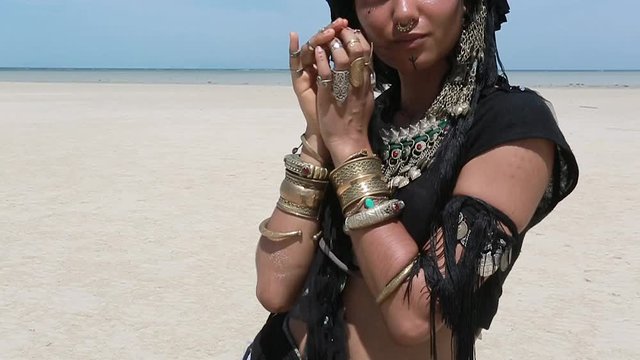 Beautiful young stylish tribal dancer. Woman in oriental costume dancing outdoors. Close up hands
