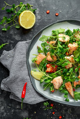 Fresh Salmon salad in asian style with sesame seeds, chili, lemon and green vegetables