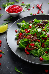 Spicy crispy duck salad with pomegranate seeds, lime and wild green rucola