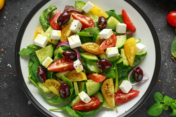 Fresh Greek salad with cucumber, cherry tomato, lettuce, red onion, feta cheese and black olives. Healthy food