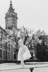 Obraz premium Ballerina dancing on the street.Young beautiful ballerina in dress and pointe shoes dancing outdoors. Ballerina posing in the center of Europe 