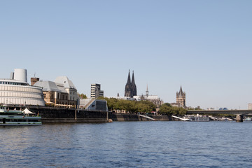 Fototapeta premium skyline mit kölner dom und weiteren hochhäusern am rhein ufer fotografiert während einer sightseeing bootstour auf dem rhein in köln deutschland