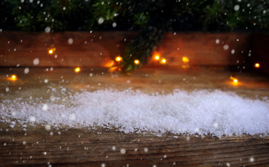 weihnachtlicher Hintergrund, Schnee, Lichtfunkeln, Tannenzweige auf Holz mit Schneeflocken 