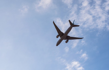  Passenger airplane flying on blue sky background is preparing to land