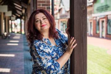 Portrait of attractive plus size mature woman in casual style walk at city at good sunny autumn day...