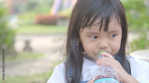 Asian Child Cute Or Kid Girl Thirsty And Drinking Cold Water In Plastic Bottle By Tube For Healthy And Refresh On Summer Holiday Travel At Public Park And Asian Child Cute Or Kid Girl Thirsty And Drinking Cold Water In Plastic Bottle By Tube For Healthy And Refresh On Summer Holiday Travel At Public Park And