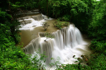 waterfall with red water because cataract on rainy season and rock for holiday relax with tree and root in the jungle or forest at Huay Mae Khamin waterfall floor 4 for nature landscape and background