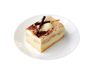 Traditional italian dessert tiramisu/ tiramisu cake with cream mascarpone and cacao powder on a white plate. White background. Close up. Isolated