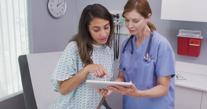 Closeup of senior nurse using tablet computer to share test results with patient