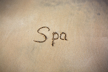 Word Spa written on the sand near the sea.Vacation concept.