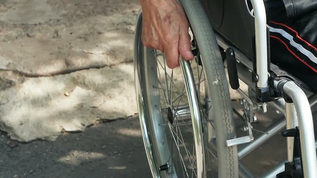 Close-up Of A Disabled Man Pushing Wheel Of Wheelchair