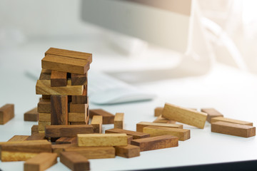 The risk will happen. engineer playing a blocks wood game on wood table vintage tone. architectural project .as background business concept with copy space.