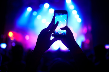 Fototapeta na wymiar Use advanced mobile recording, fun concerts and beautiful lighting, Candid image of crowd at rock concert, Close up of recording video with smartphone, Enjoy the use of mobile photography.