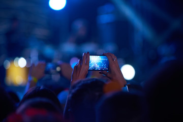 Use advanced mobile recording, fun concerts and beautiful lighting, Candid image of crowd at rock...