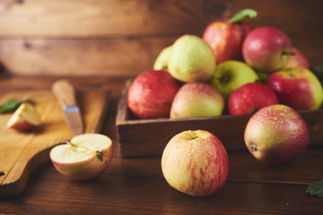 Fresh ripe apple in bowl , cutting board with knife and half of apple
