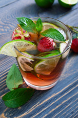 Fresh cool strawberry mojito in a glass on a wooden table.