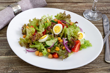 Dietary, vegetarian salad with quail eggs, fresh herbs, chickpeas, red onions and cherry tomatoes.