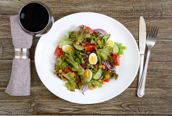 Dietary, vegetarian salad with quail eggs, fresh herbs, chickpeas, red onions and cherry tomatoes.