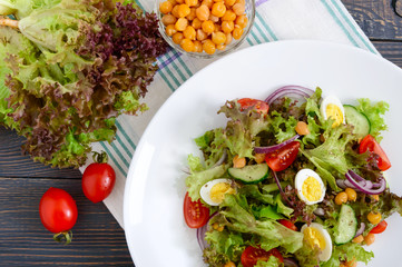 Dietary, vegetarian salad with quail eggs, fresh herbs, chickpeas, red onions and cherry tomatoes.