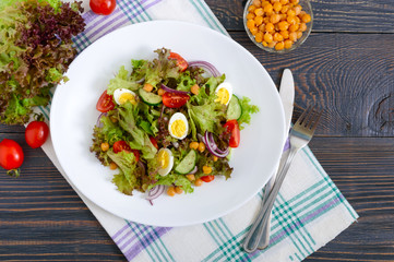 Dietary, vegetarian salad with quail eggs, fresh herbs, chickpeas, red onions and cherry tomatoes.