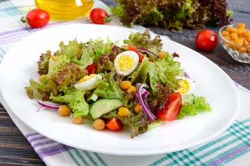 Dietary, vegetarian salad with quail eggs, fresh herbs, chickpeas, red onions and cherry tomatoes.