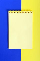 Yellow-blue background. Free space for your project. Two-color abstract background with a notepad in the middle.