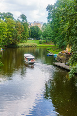 Fototapeta na wymiar 18.08. 2018 The Kronvalds Park, Riga, Latvia. Urban park with a canal, seasonal boating, plus paths, fountains. One of the most favorite recreation places of Riga. Sightseeing in Riga.