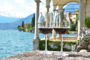 Two wineglasses. Varenna town at the lake Como, Italy - 220637281