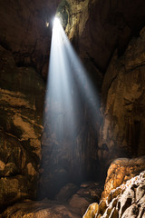 Shafts of sunlight from Mulu cave roof illuminate the chamber