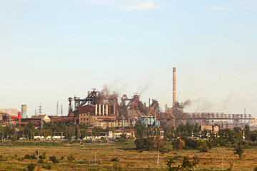 Large industrial plant with smoking factory pipes.
