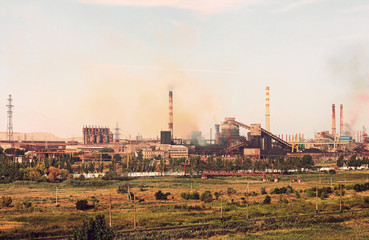 Fototapeta na wymiar Panoramic view of the large industrial plant with smoking factory chimneys on chemical sky background.