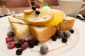 Honey toast bread with fruits and ice cream as topping.