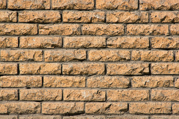 Texture of a wall of yellow scratched bricks