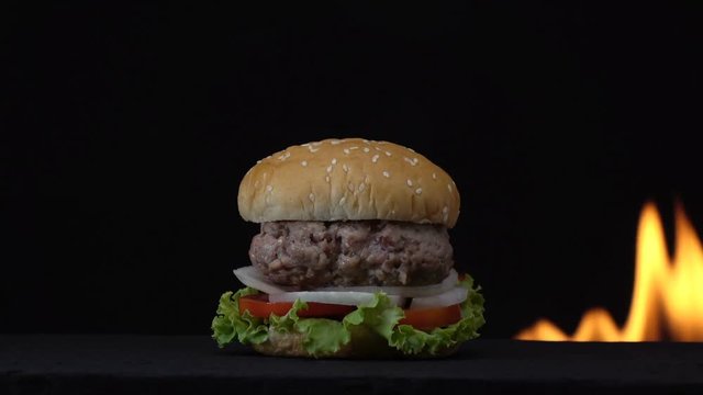 Hamburger fast food on fire slow motion background.