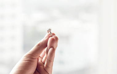 Obraz premium ็Hand hold diamond ring with blur background. symbol of wedding, marriage and love. 