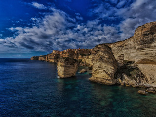 Fototapeta na wymiar Limestone cliffs and the old fort Bonifacio under the dramatic sky.