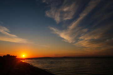 Naklejka na ściany i meble Beautiful sunset over the sandy sea beach