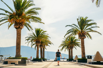 Obraz premium man walking by pier in summer day